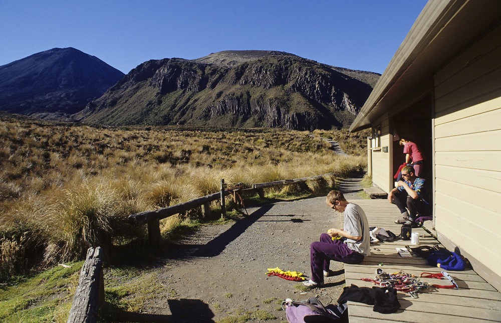 An der Mangatepopo-Hütte sind Kletterer früh aufgestanden und bereiten ihre Ausrüstung vor. Ihr Ziel sind die Wände des Pukikaikiore im Hintergrund, die zu den Kletterhighlights in Neuseeland zählen