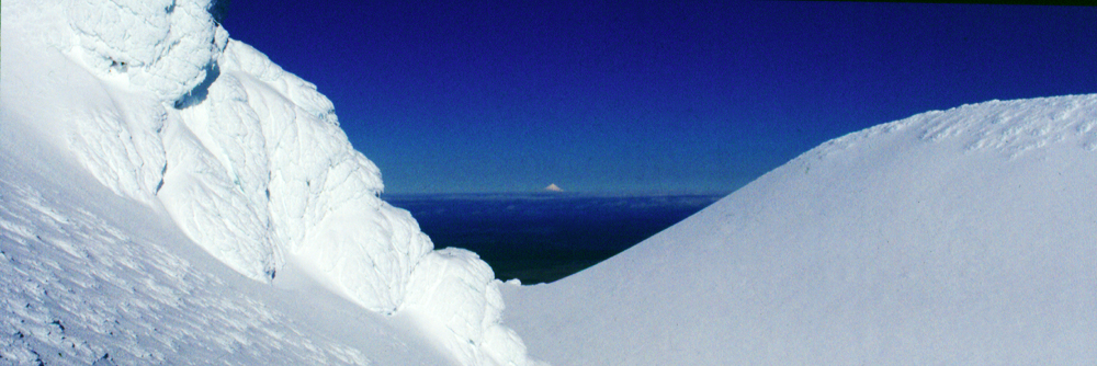 Nach einem Aufstieg mit Steigeisen reicht der Blick vom Gipfel des Ngauruhoe bis hinüber zum Vulkan Taranaki