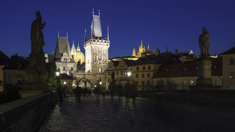 Menschen flanieren über die Karlsbrücke bei Nacht, Prag, Tschechien