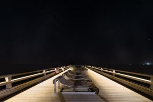 Sternenhimmel über der beleuchteten Seebrücke von Heiligenhafen an der Ostsee, Schleswig-Holstein, Deutschland
