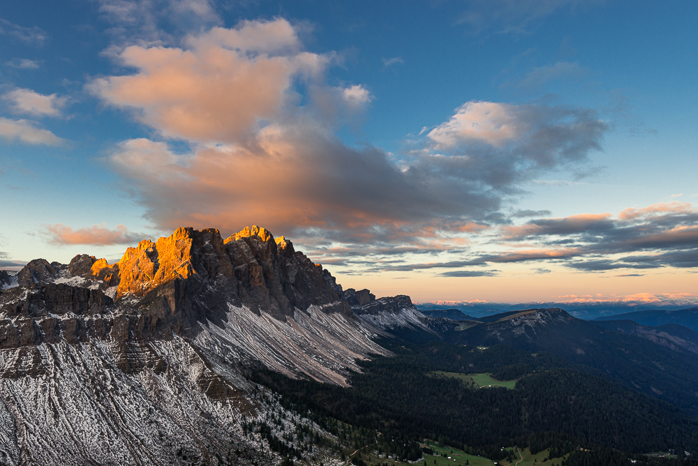 Wolken und die Felsen der Geislerspitzen leuchten golden im Sonnenlicht bei Sonnenaufgang über der Puez-Geisler-Gruppe und den Dolomiten, Villnößtal, Südtirol, Italien