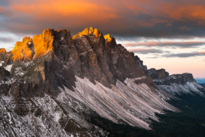 Wolken und die Felsen der Geislerspitzen leuchten golden im Sonnenlicht bei Sonnenaufgang über der Puez-Geisler-Gruppe und den Dolomiten, Villnößtal, Südtirol, Italien
