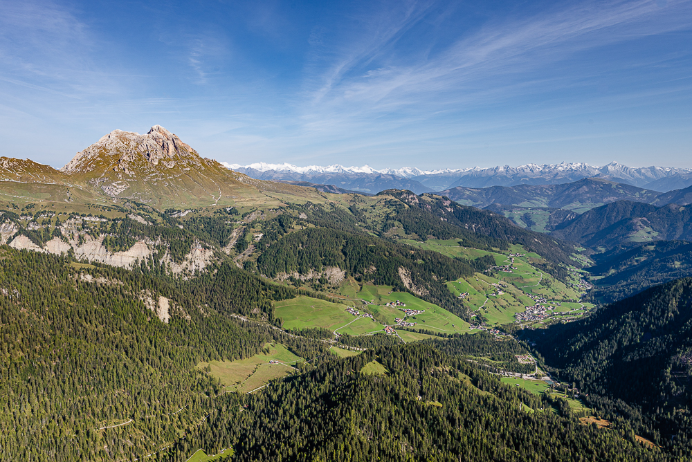 Das herbstliche Campilltal mit dem Peitlerkofel in den Dolomiten vor dem Panorama des Alpenhauptkamms, Südtirol, Italien