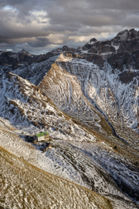 Die Schlüterhütte Rifugio Genova vor verschneiten Bergen und Felsgipfeln der Puez-Geisler-Gruppe in den Dolomiten, Südtirol, Italien