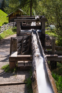 Hölzerne Wasserleitung für das Wasserrad einer historischen Getreidemühle im Mühlental von Campill an, Südtirol, Italien