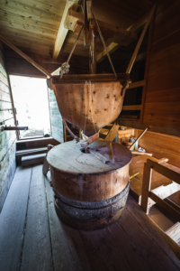 Hölzernes Mahlwerk im Innern der historischen Getreidemühle im Mühlental von Campill, Südtirol, Italien