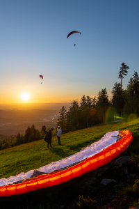 Gleitschirmflieger am Startplatz der Teufelsmühle im Murgtal im Schwarzwald beim Start in den Sonnenuntergang, Baden-Württemberg, Deutschland