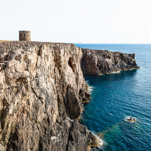 Der verfallene Küstenwachtturm Torre Spagnola auf den rauhen Karstfelsen der Steilküste an der Cala Domestica, Iglesiente, Sardinien, Italien