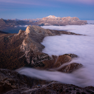 Kaltluftnebel fliesst über den Valparola-Pass vor dem Settsass und dem Sellamassiv in der Morgendämmerung, Dolomiten, Italien