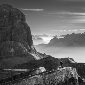 Selbstportrait in der Morgensonne auf einem Felsband an der Lagazuoi Seilbahn vor dem Gipfel der Tofan di Rozes und den Bergketten der Dolomiten bei Cortina d'Ampezzo, Italien