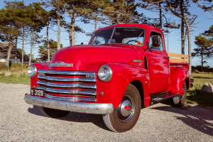 Ein alter roter Chevrolet 3100 Pickup Classic Car auf einem Parkplatz an der Küste von Dänemark