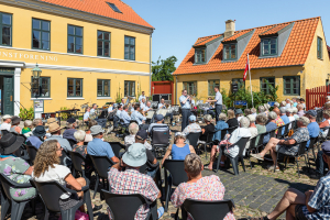 Zuhörer bei einem Sommerkonzert des Prinsens Musikkorps auf dem Marktplatz in der Altstadt von Ebeltoft, Djursland, Jütland, Dänemark