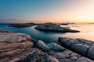 Leuchtendender Sonnenuntergang auf den Felsen im Naturreservat Tjurpannan in den Schären der schwedischen Westküste
