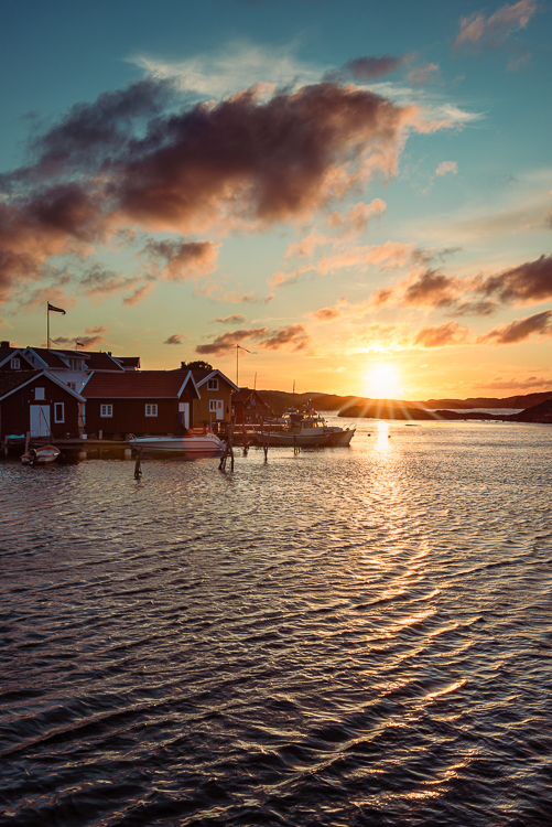 Sonnenuntergang mit dramatischem Himmel über dem Hafen von Björholmen auf der Insel Tjörn in den Schären der Westküste von Schweden