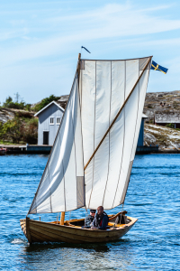 Eine historische Orust-Jolle segelt im Hafen von Mollösund auf der Insel Orust in den Schären der Westküste von Schweden