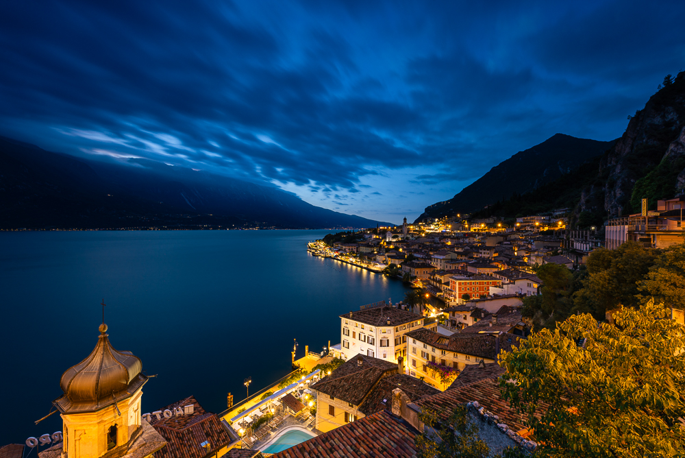Aussicht über die nächtlich beleuchtete Stadt Limone am Gardasee in der Blauen Stunde der Morgendämmerung, Lombardei, Italien