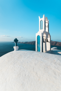 Die Heilige Kirche von Panagia Theoskepasti vor dem Panorama der Caldera von Santorin mit Oia und Thirasia, Kykladen, Greichenland
