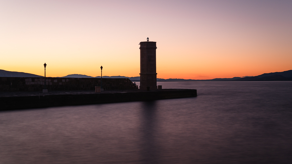 Hafenmole und Leuchtturm von Senj an der kroatischen Adriaküste im Gegenlicht der leuchtenden Abenddämmerung über der Insel Krk Hafenmole und Leuchtturm von Senj an der kroatischen Adriaküste im Gegenlicht der leuchtenden Abenddämmerung über der Insel Krk