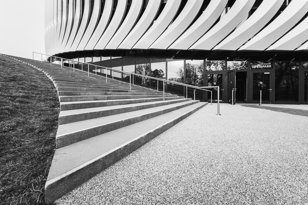 Treppe vor der modernen Fassade der SAP Garden Mehrzweckhalle mit gebogenen Aluminium-Lamellen und Glas im Olympiapark München, Deutschland Treppe vor der modernen Fassade der SAP Garden Mehrzweckhalle mit gebogenen Aluminium-Lamellen und Glas im Olympiapark München, Deutschland