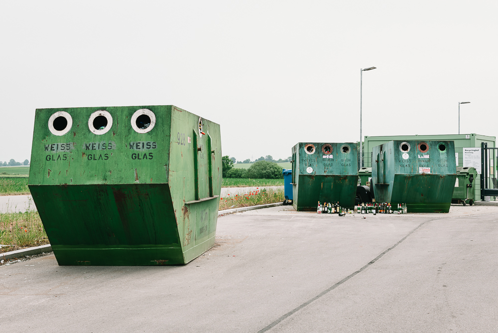 Container zur Sammlung von Altglas, Altpapier, Altmetall und Altkleider auf einem asphaltierten Platz am Ortsrand einer bayrischem Gemeinde Container zur Sammlung von Altglas, Altpapier, Altmetall und Altkleider auf einem asphaltierten Platz am Ortsrand einer bayrischem Gemeinde