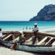 Frauen sitzen auf einem Holzboot am Strand von San Pedro und warten auf die Rückkehr der Fischer, Sao Vicente, Kapverden