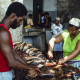 Männer und Frauen beim Ausnehmen und Filetieren von frisch gefangenem Fisch im Fischmarkt von Mindelo, Sao Vicente, Kapverde