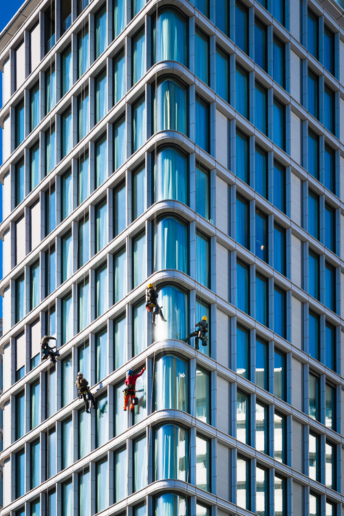 Fensterputzer an der Außenfassade eines modernen Hochhauses in Wien, Österreich