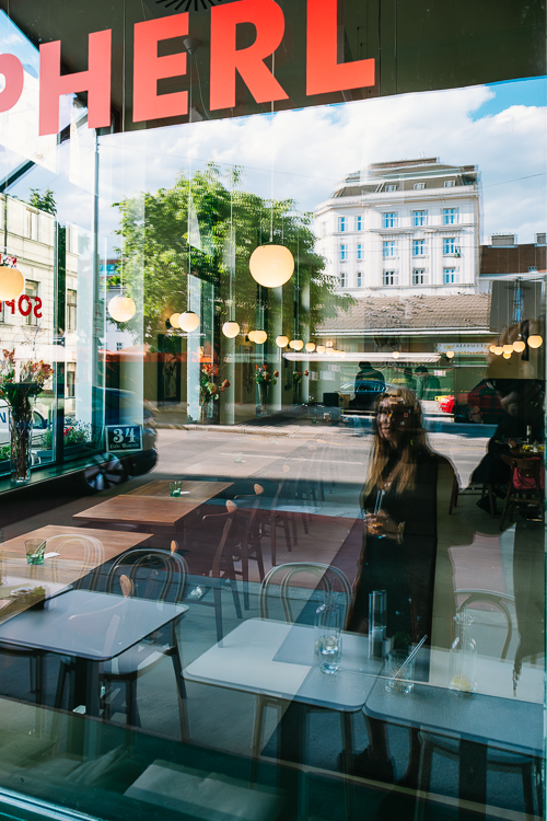 Spiegelung von Architektur und der Künstlerin Jaz im Fenster des Restaurants Sopherl am Naschmarkt, Wien, Österreich Spiegelung von Architektur und der Künstlerin Jaz im Fenster des Restaurants Sopherl am Naschmarkt, Wien, Österreich